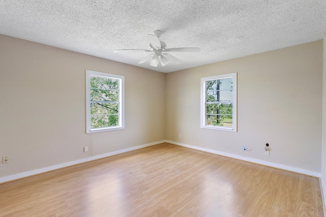 spare room with a wealth of natural light, ceiling fan, a textured ceiling, and light hardwood / wood-style floors