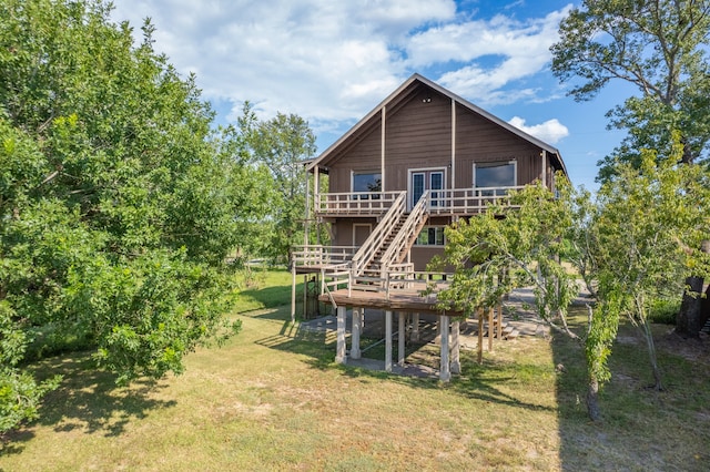 back of house featuring a lawn and a deck