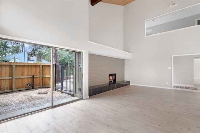 unfurnished living room with a towering ceiling and wood-type flooring