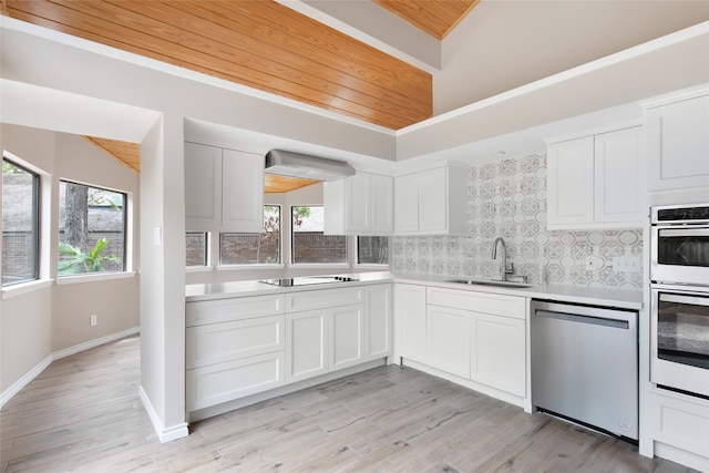 kitchen with light hardwood / wood-style flooring, appliances with stainless steel finishes, sink, wall chimney range hood, and white cabinets