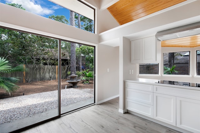 entryway with lofted ceiling, light hardwood / wood-style floors, and wooden ceiling