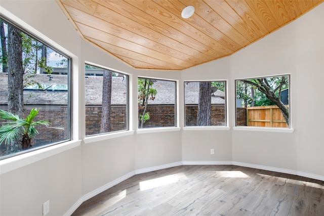 unfurnished sunroom with a healthy amount of sunlight, vaulted ceiling, and wooden ceiling