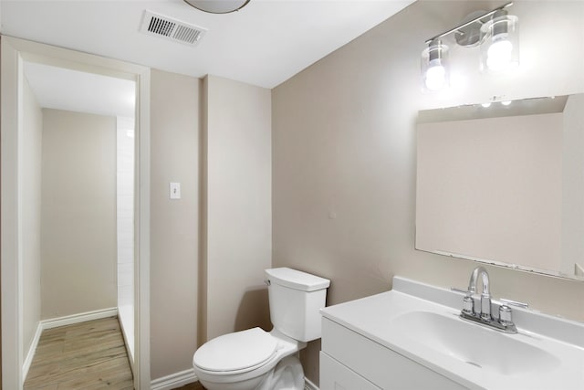 bathroom featuring toilet, hardwood / wood-style flooring, and vanity