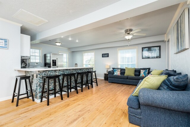 living room with ceiling fan and light hardwood / wood-style flooring