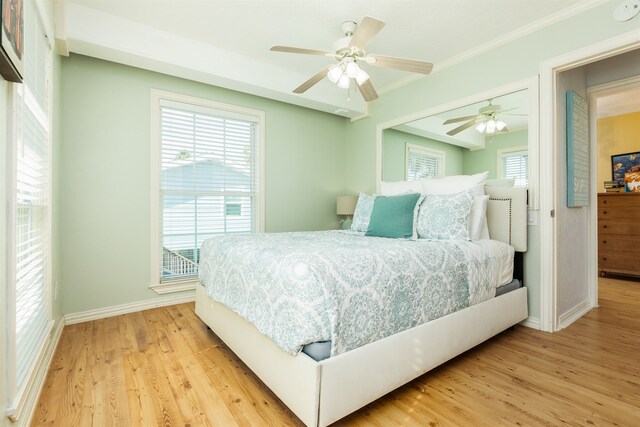 bedroom featuring light wood-type flooring, multiple windows, and ceiling fan