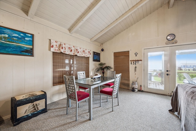 carpeted dining area with french doors and lofted ceiling with beams