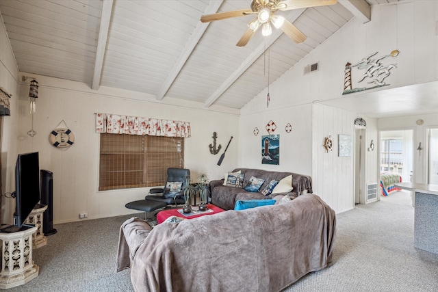 carpeted living room with high vaulted ceiling, beam ceiling, ceiling fan, and wooden walls