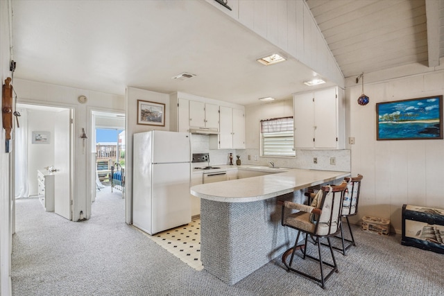 kitchen featuring kitchen peninsula, white appliances, a wealth of natural light, and white cabinetry