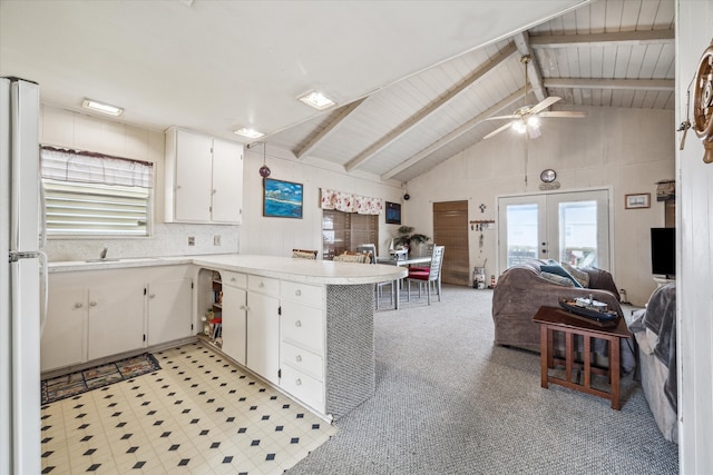 kitchen featuring french doors, kitchen peninsula, white cabinetry, ceiling fan, and vaulted ceiling with beams