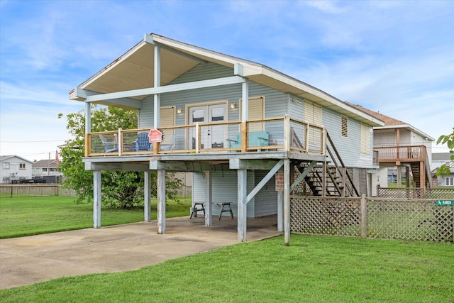 back of house with a yard, a carport, and a wooden deck