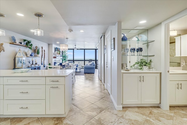 kitchen with pendant lighting, a wall of windows, and white cabinetry