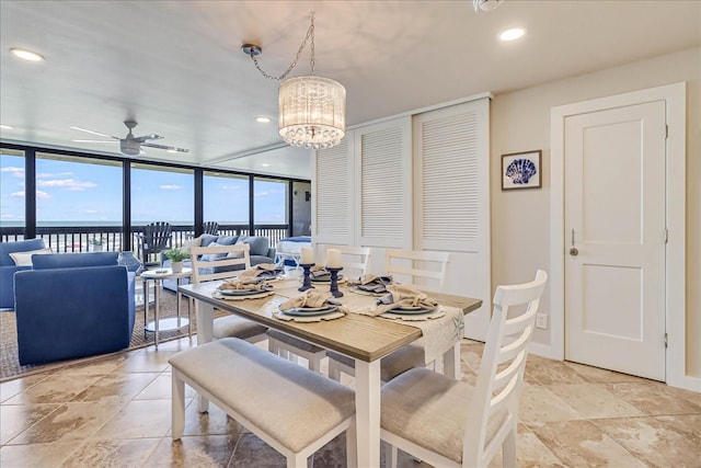 dining space featuring floor to ceiling windows and ceiling fan with notable chandelier