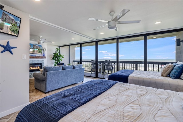 bedroom with a water view, tile patterned flooring, a wall of windows, access to exterior, and ceiling fan