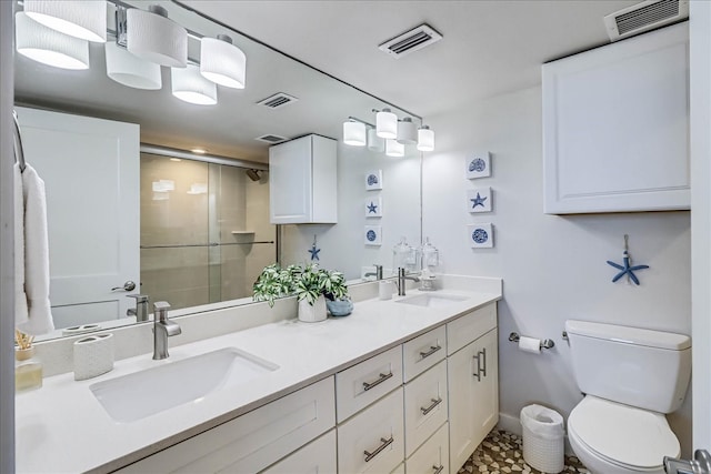 bathroom featuring toilet, a shower with door, and vanity