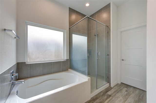 bathroom featuring hardwood / wood-style floors, a healthy amount of sunlight, and independent shower and bath