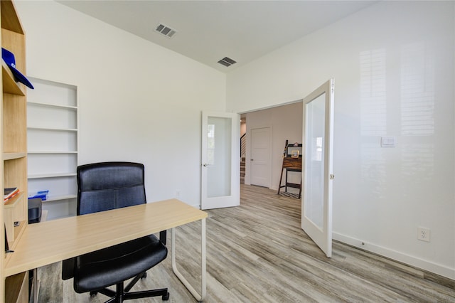 home office with light hardwood / wood-style floors