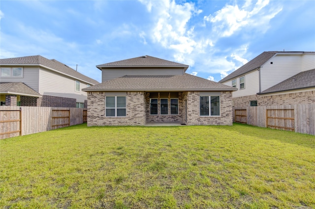 back of property with a yard and a patio area