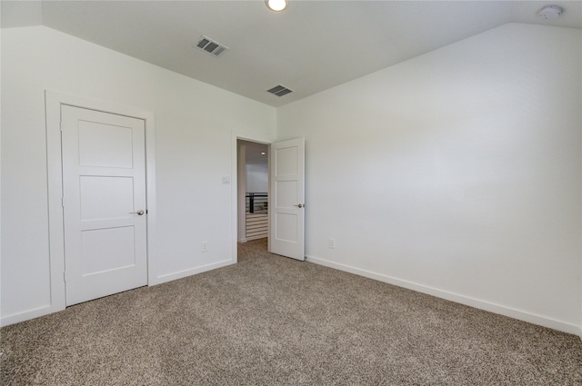 unfurnished bedroom with carpet and vaulted ceiling