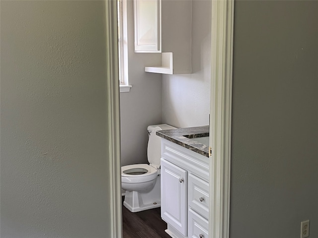 bathroom with hardwood / wood-style floors, toilet, and vanity