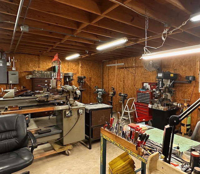 interior space with a workshop area, electric panel, and concrete flooring