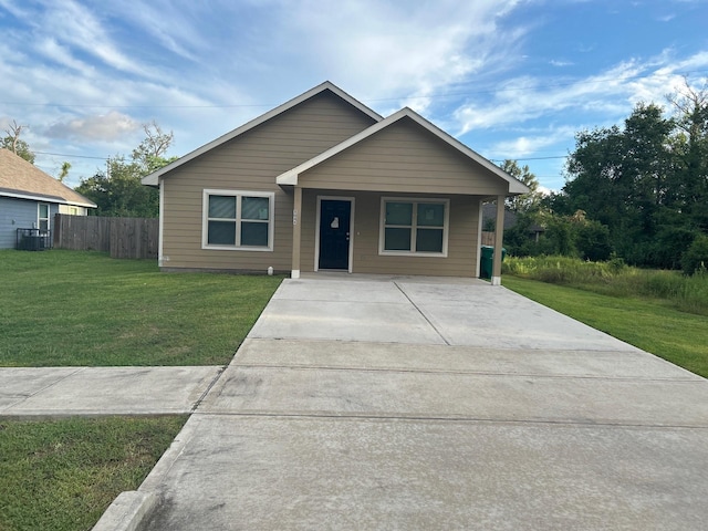 view of front of home featuring central AC unit, fence, and a front lawn