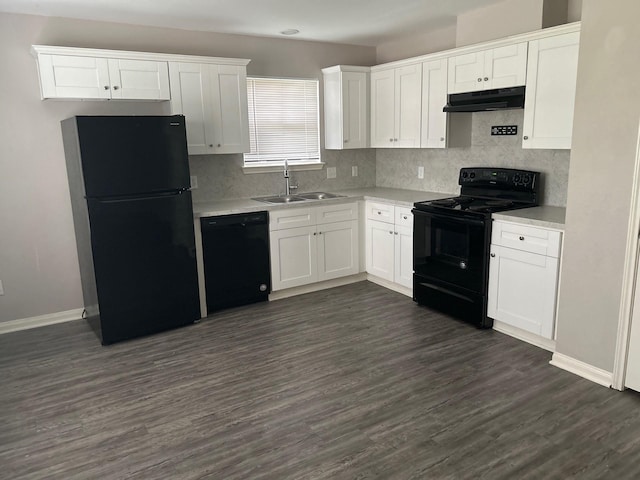 kitchen with light countertops, white cabinets, a sink, under cabinet range hood, and black appliances