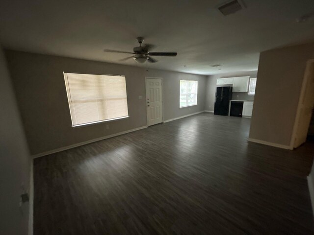 unfurnished living room with ceiling fan and dark hardwood / wood-style flooring