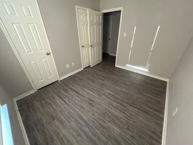 unfurnished bedroom with dark hardwood / wood-style flooring