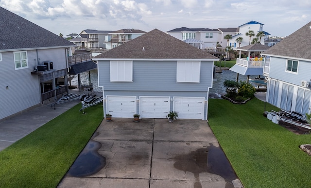 view of front of property featuring a balcony, a garage, and a front lawn