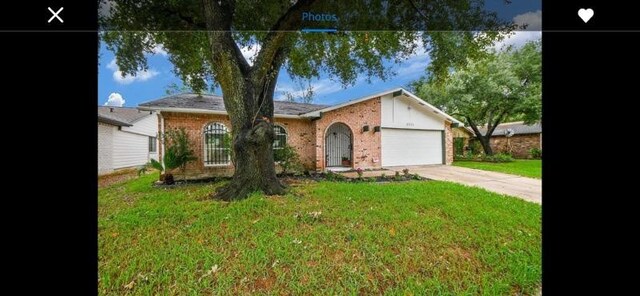 ranch-style home with a garage and a front lawn