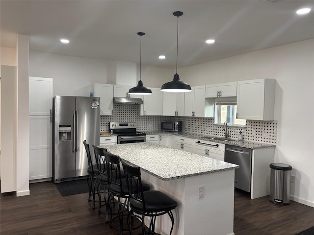 kitchen featuring a center island, white cabinets, hanging light fixtures, sink, and appliances with stainless steel finishes