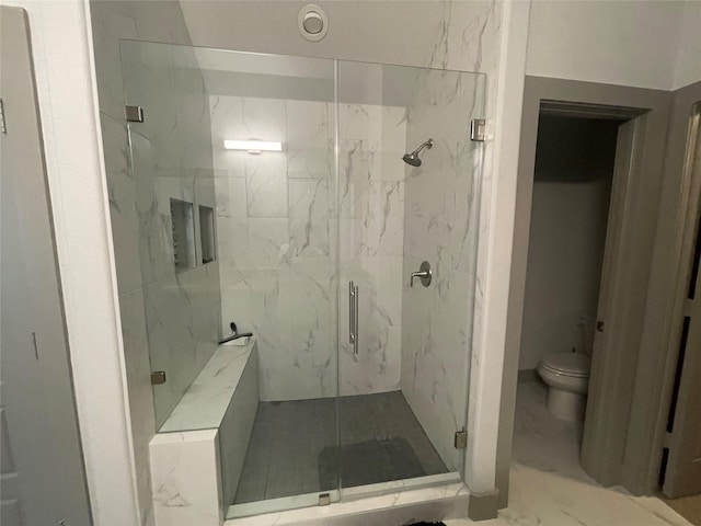 bathroom featuring toilet, marble finish floor, and a marble finish shower