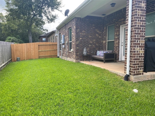 view of yard with a patio area, a fenced backyard, and an outdoor living space