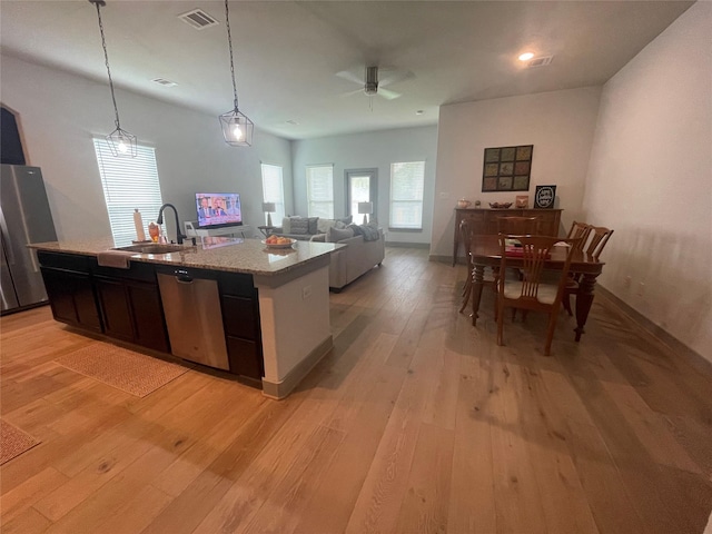 kitchen featuring visible vents, light wood-type flooring, appliances with stainless steel finishes, a ceiling fan, and a sink