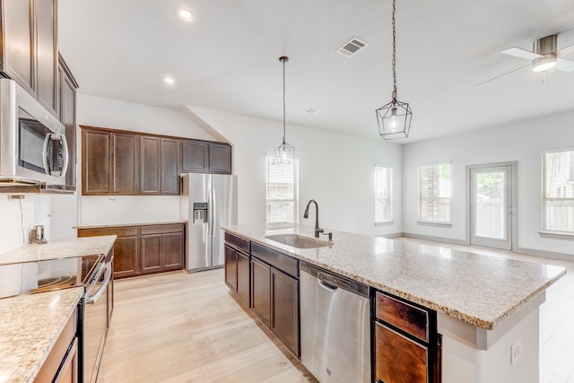 11913 Mockingbird Ln, Montgomery, TX 77356 - kitchen featuring stainless steel appliances, a sink, light wood-style floors, ceiling fan, and decorative light fixtures