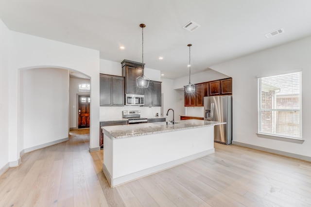 11913 Mockingbird Ln, Montgomery, TX 77356 - kitchen with appliances with stainless steel finishes, a sink, arched walkways, light wood-type flooring, and recessed lighting