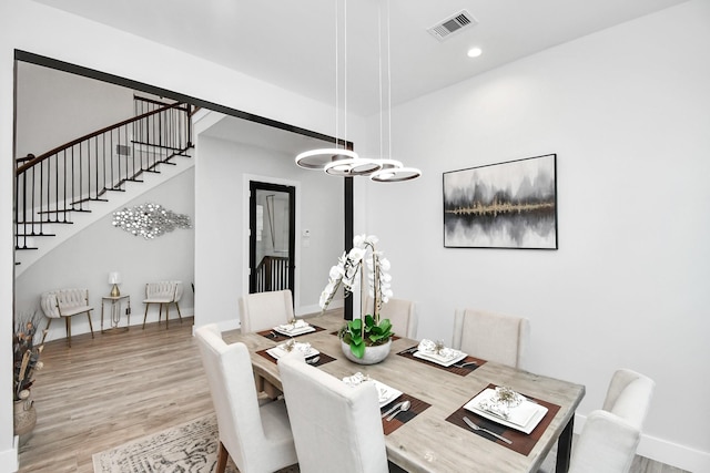 dining room with light hardwood / wood-style flooring and an inviting chandelier