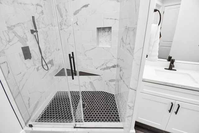 bathroom with a shower with door and vanity