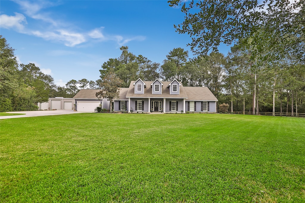 cape cod-style house with a front yard and a garage