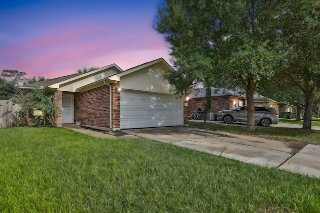 ranch-style house with a garage and a lawn