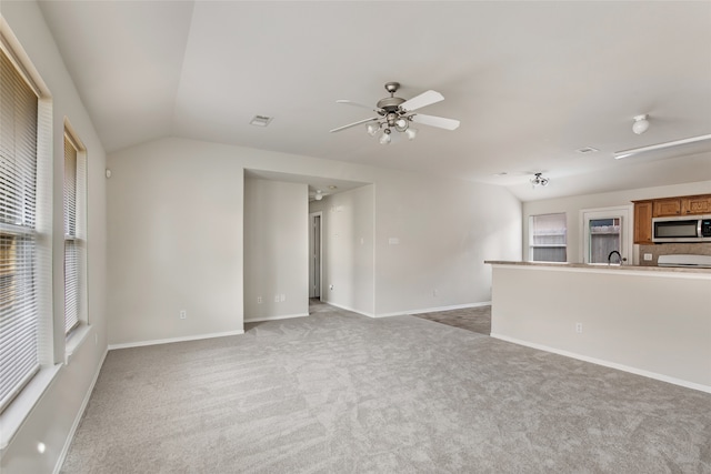 unfurnished living room featuring carpet flooring, ceiling fan, and vaulted ceiling