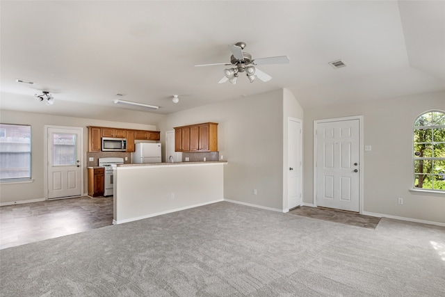 unfurnished living room featuring lofted ceiling, ceiling fan, sink, and carpet floors