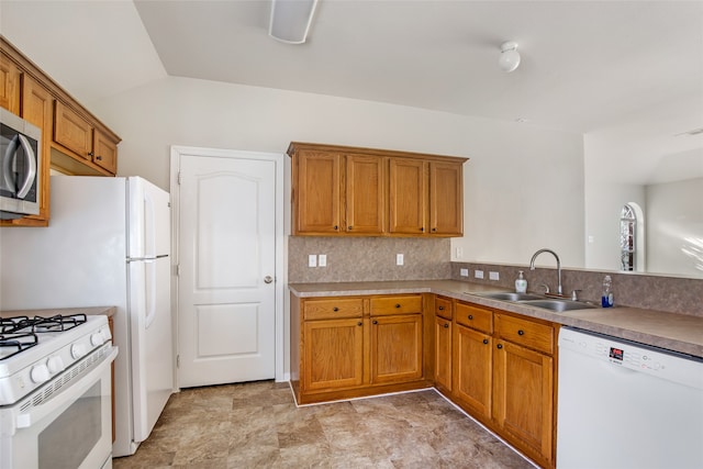 kitchen featuring white appliances, decorative backsplash, vaulted ceiling, and sink