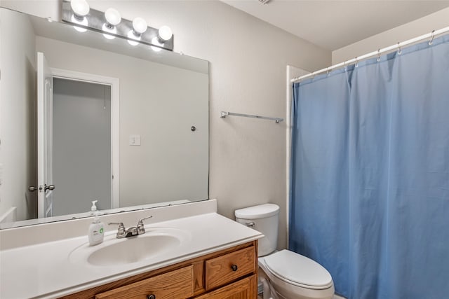 bathroom with walk in shower, toilet, and vanity