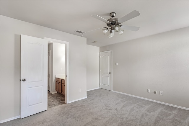 unfurnished bedroom featuring ceiling fan, light colored carpet, and ensuite bathroom