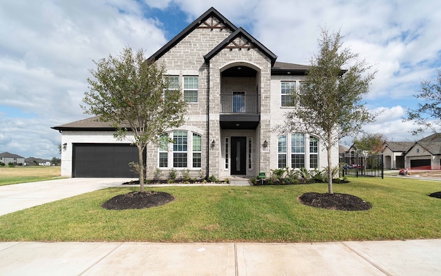 french provincial home featuring a balcony, a front yard, and a garage