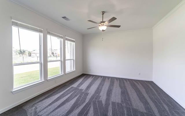 spare room featuring crown molding, dark colored carpet, and a healthy amount of sunlight