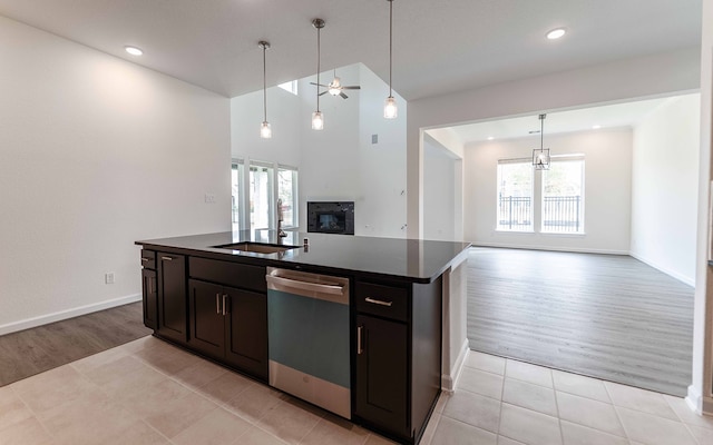 kitchen with light hardwood / wood-style floors, dishwasher, a kitchen island with sink, and sink