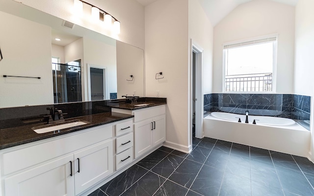 bathroom featuring vanity, vaulted ceiling, shower with separate bathtub, and plenty of natural light