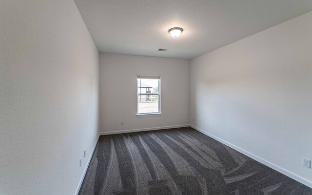 carpeted spare room with a textured ceiling